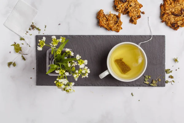 Green (herbal, white) tea with cookies on white background. Flat lay food, breakfast lifeslyle concept