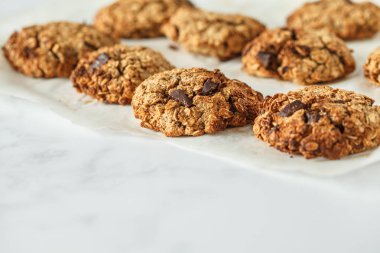 Vegan yulaf ezmeli kurabiye çikolata üzerinde hafif bir arka plan ile. Gıda blog stil kavramı.