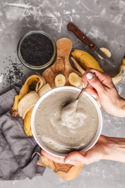 Gri muz ve siyah susam süt smoothie gri bir arka plan üzerinde top. Sağlıklı vegan gıda kavramı.