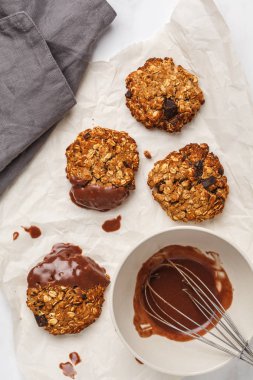 Vegan yulaf ezmeli kurabiye çikolata üzerinde hafif bir arka plan ile. Gıda blog stil kavramı.