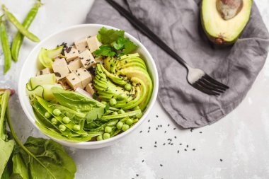 Tofu, pirinç, avokado ve sebze ile yeşil Buda kase. Vegan kavramı git.