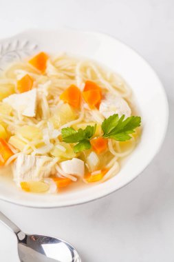 Tavuk çorbası erişte ve sebze beyaz tabak, beyaz arka plan ile.
