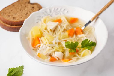 Tavuk çorbası erişte ve sebze beyaz tabak, beyaz arka plan ile.