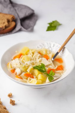 Tavuk çorbası erişte ve sebze beyaz tabak, beyaz arka plan ile.