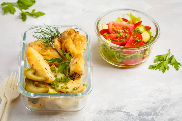 Healthy meal prep containers with baked chicken, potatoes and vegetable salad overhead shot with copy space