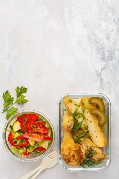 Healthy meal prep containers with baked chicken, potatoes and vegetable salad overhead shot with copy space