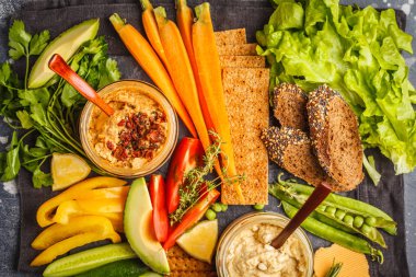 Vejetaryen Arapça DIP humus sebze ve karanlık bir arka plan üzerinde farklı atıştırmalıklar ile. Sağlıklı vegan gıda kavramı.