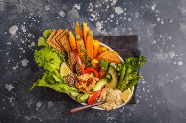 Vejetaryen Arapça DIP humus sebze ve karanlık bir arka plan üzerinde beyaz tabak içinde farklı atıştırmalıklar ile. Sağlıklı vegan gıda kavramı.