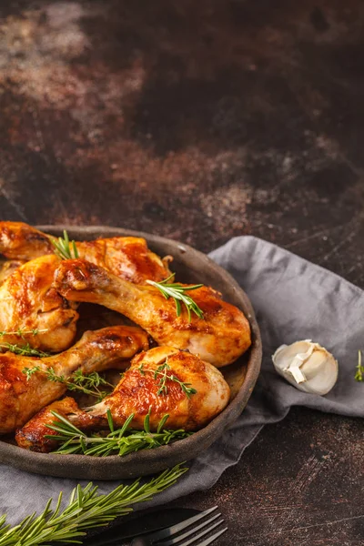 Izgara baharatlı tavuk budu sarımsak, biberiye ve kekik koyu arka plan, kopya alanı üzerinde karanlık tabak pişmiş