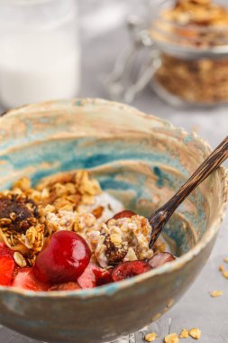 Ev yapımı granola Hindistan cevizi yoğurt ve çilek ile. Sağlıklı vegan gıda kavramı.