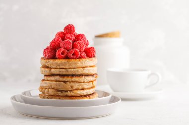 Ahududu ve beyaz tabak, beyaz arka plan üzerinde chia tohum ile Vegan krep. Sağlıklı vegan gıda kavramı.