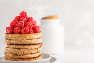 Ahududu ve beyaz tabak, beyaz arka plan üzerinde chia tohum ile Vegan krep. Sağlıklı vegan gıda kavramı.