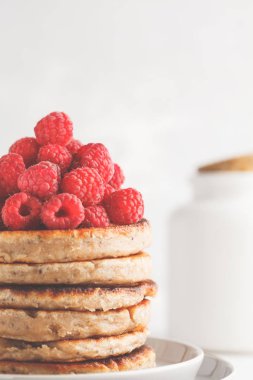 Ahududu ve beyaz tabak, beyaz arka plan üzerinde chia tohum ile Vegan krep. Sağlıklı vegan gıda kavramı.