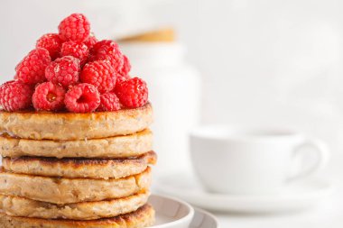 Ahududu ve beyaz tabak, beyaz arka plan üzerinde chia tohum ile Vegan krep. Sağlıklı vegan gıda kavramı.