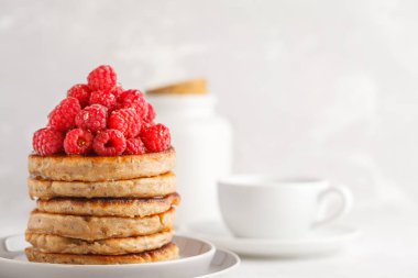 Ahududu ve beyaz tabak, beyaz arka plan üzerinde chia tohum ile Vegan krep. Sağlıklı vegan gıda kavramı.