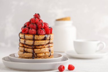 Ahududu ve çikolata beyaz tabak, beyaz arka plan üzerinde ile ev yapımı vegan krep. Sağlıklı vegan gıda kavramı.