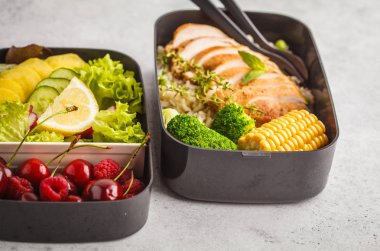 Sağlıklı yemek kapları ile meyve, çilek, pilav ve sebze ızgara tavuk ile hazırlayın. Beyaz arka plan üzerinde paket servisi olan restoran gıda