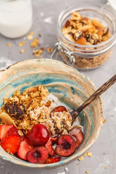 Ev yapımı granola Hindistan cevizi yoğurt ve çilek ile. Sağlıklı vegan gıda kavramı.