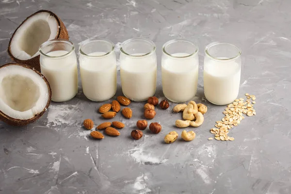 Vegan alternatif fındık süt gri bir arka plan üzerinde cam şişelerde. Sağlıklı vegan gıda kavramı.