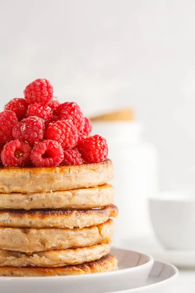 Ahududu ve beyaz tabak, beyaz arka plan üzerinde chia tohum ile Vegan krep. Sağlıklı vegan gıda kavramı.