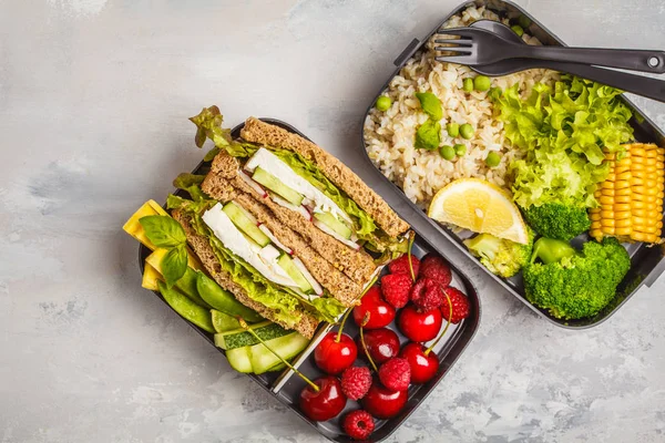 Sağlıklı yemek kapları ile meyve, çilek, pilav ve sebze ile beyaz peynir sandviç hazırlayın. Sağlıklı vejetaryen gıda kavramı. Paket servisi olan restoran gıda.