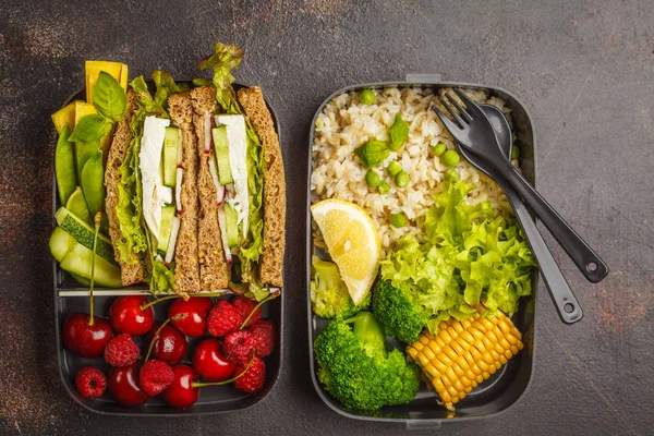 Healthy meal prep containers with feta sandwich with fruits, berries, rice and vegetables. Healthy vegetarian food concept. Takeaway food.