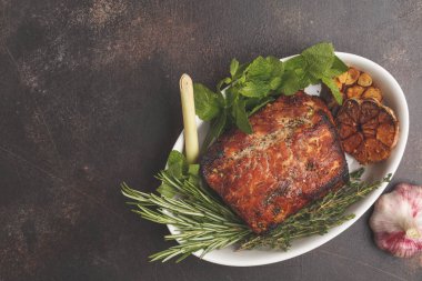 Hardal, biberiye, beyaz bir tabak, koyu arka plan, sarımsak soslu domuz eti pişmiş alanı Kopyala.