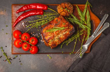 Kekik, biberiye, ahşap bir masa, koyu arka plan, sarımsak soslu domuz eti pişmiş alanı Kopyala.