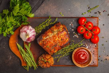 Kekik, biberiye, ahşap bir masa, koyu arka plan, sarımsak soslu domuz eti pişmiş alanı Kopyala.