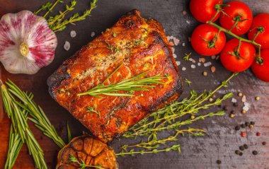 Kekik, biberiye, ahşap bir masa, koyu arka plan, sarımsak soslu domuz eti pişmiş alanı Kopyala.