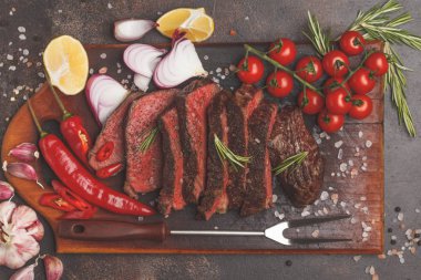 Baharat ve sebzeler, üstten görünüm ile ahşap bir gemide biftek dilimlenmiş, kopyalama alanı.