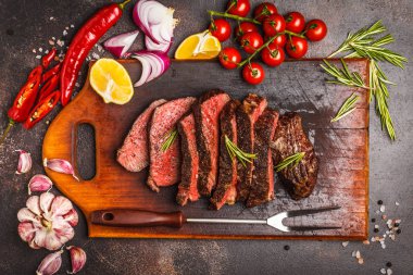 Baharat ve sebzeler, üstten görünüm ile ahşap bir gemide biftek dilimlenmiş, kopyalama alanı.