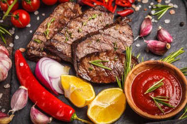 Baharatlar ve sebzeler kayrak tahta, koyu arka plan üzerinde ızgara sığır eti biftek