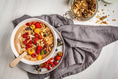 Muz, kakao, çilek ve ev yapımı granola ile güler yüzlü kase. Vejetaryen kahvaltı muzlu dondurma. Sağlıklı vegan gıda kavramı.