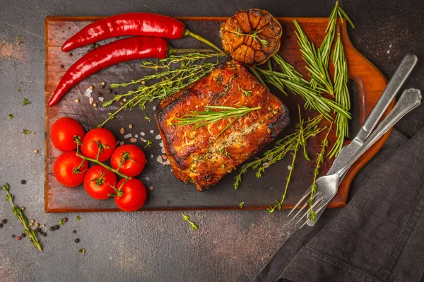 Kekik, biberiye, ahşap bir masa, koyu arka plan, sarımsak soslu domuz eti pişmiş alanı Kopyala.