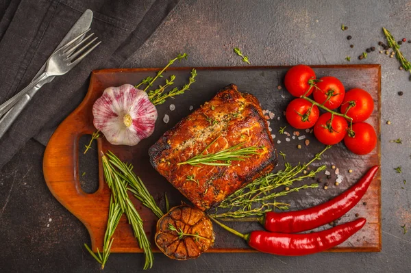 Kekik, biberiye, ahşap bir masa, koyu arka plan, sarımsak soslu domuz eti pişmiş alanı Kopyala.