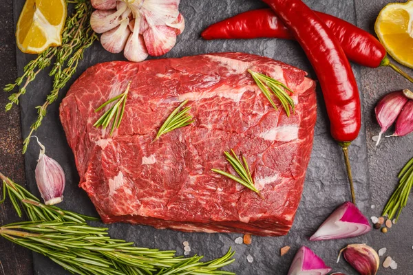 Sığır eti kayrak ile baharat, koyu arka plan, kopya alanı üzerinde ham bütün parça.
