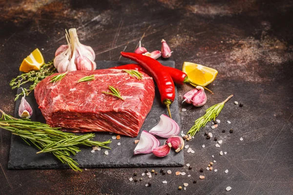 Sığır eti kayrak ile baharat, koyu arka plan, kopya alanı üzerinde ham bütün parça.