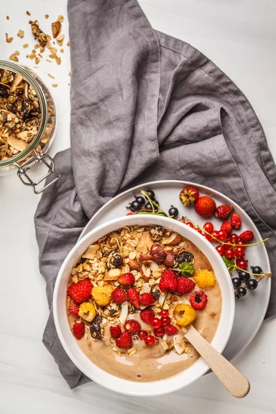 Muz, kakao, çilek ve ev yapımı granola ile güler yüzlü kase. Vejetaryen kahvaltı muzlu dondurma. Sağlıklı vegan gıda kavramı.