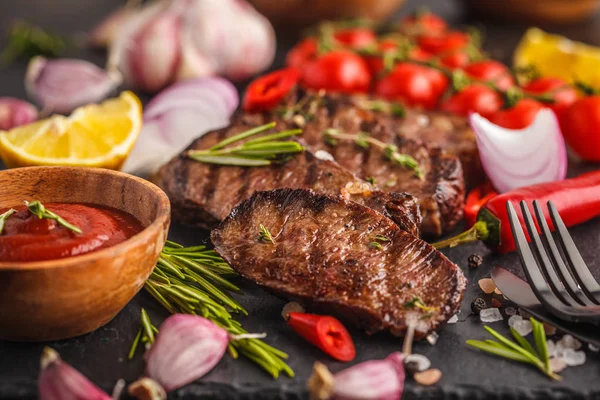 Baharatlar ve sebzeler kayrak tahta, koyu arka plan üzerinde ızgara sığır eti biftek