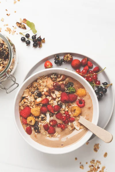 Muz, kakao, çilek ve ev yapımı granola ile güler yüzlü kase. Vejetaryen kahvaltı muzlu dondurma. Sağlıklı vegan gıda kavramı.