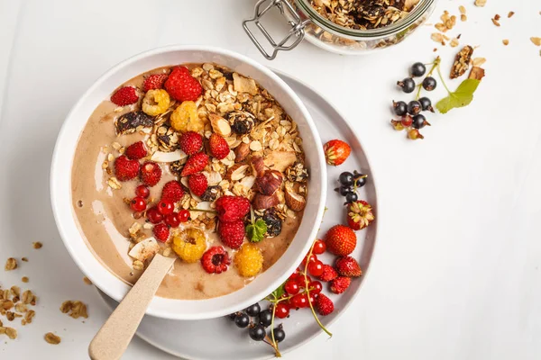 Muz, kakao, çilek ve ev yapımı granola ile güler yüzlü kase. Vejetaryen kahvaltı muzlu dondurma. Sağlıklı vegan gıda kavramı.