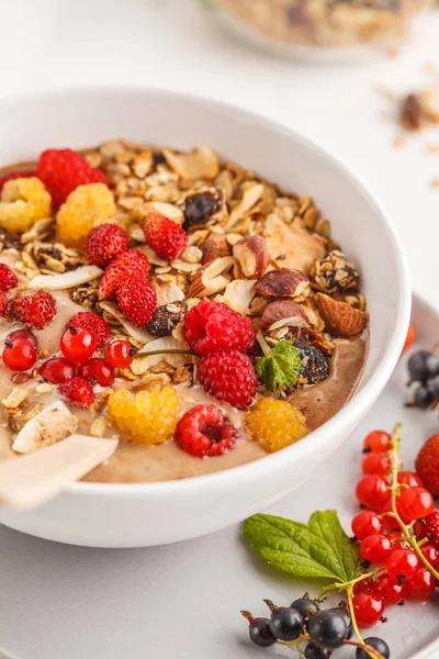 Muz, kakao, çilek ve ev yapımı granola ile güler yüzlü kase. Vejetaryen kahvaltı muzlu dondurma. Sağlıklı vegan gıda kavramı.