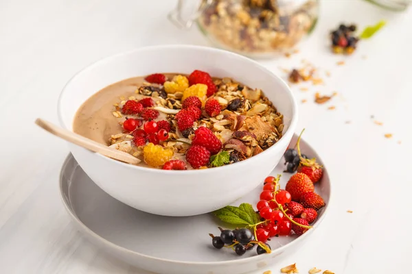 Muz, kakao, çilek ve ev yapımı granola ile güler yüzlü kase. Vejetaryen kahvaltı muzlu dondurma. Sağlıklı vegan gıda kavramı.