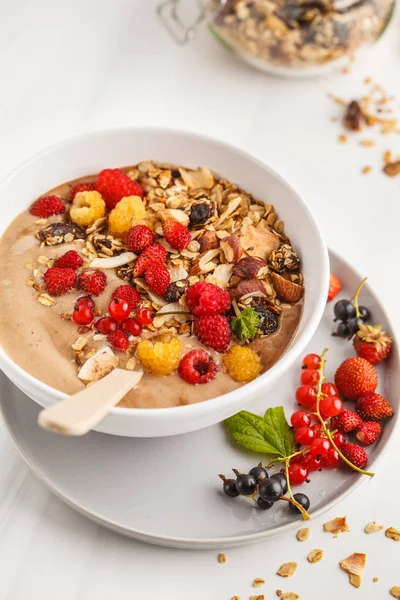 Muz, kakao, çilek ve ev yapımı granola ile güler yüzlü kase. Vejetaryen kahvaltı muzlu dondurma. Sağlıklı vegan gıda kavramı.