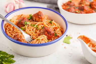 Spagetti maydanoz ile domates soslu köfte ve beyaz tabak, beyaz arka planda sarımsak ile.