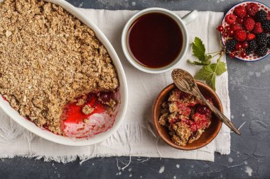 Kahve ile kahvaltı ve parçalamak pasta, koyu arka plan, sağlıklı kahvaltı kavramı, üstten görünüm. Vegan berry tatlı.