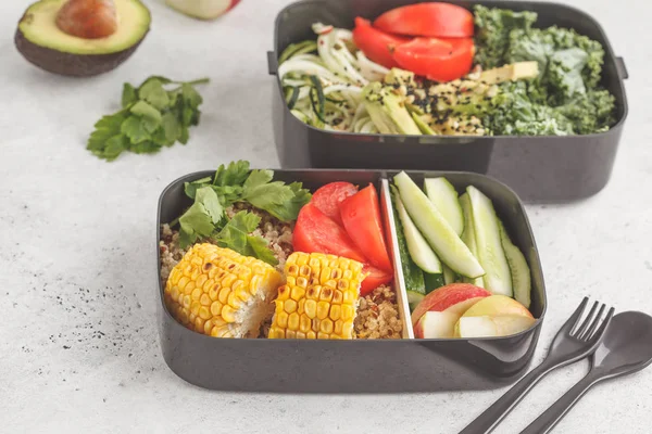 Healthy meal prep containers with quinoa, avocado, corn, zucchini noodles and kale. Takeaway food. White background, top view.