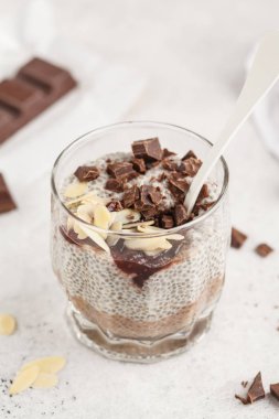 Chia puding çikolata, badem ve berry reçel, beyaz arka plan ile. Çiğ vegan tatlı. Temiz yemek kavramı.