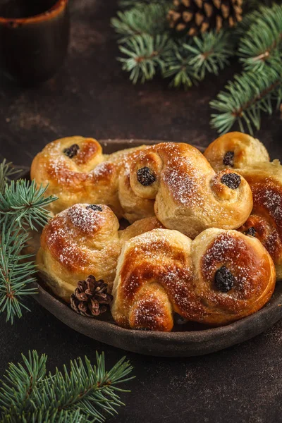 Traditional Swedish Christmas saffron buns (lussebulle or lussekatt). Swedish christmas. Dark background, Christmas decoration.